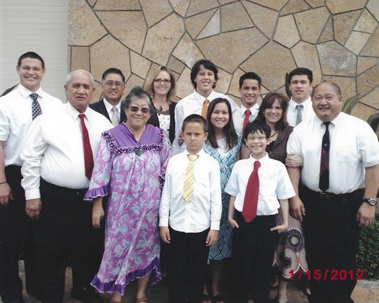 Group of family members dressed in formal clothing posing together with smiles.
