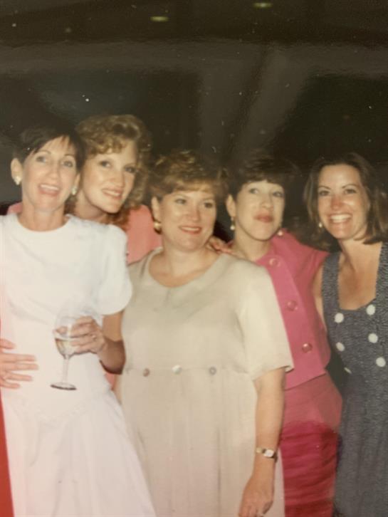 Friends gather together at a festive party, sharing laughter and drinks in a joyful atmosphere.