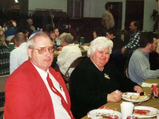 A group of people share a meal in a lively atmosphere during a community gathering.