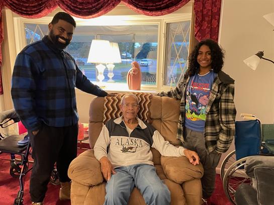 A group of people standing next to a man in a chair