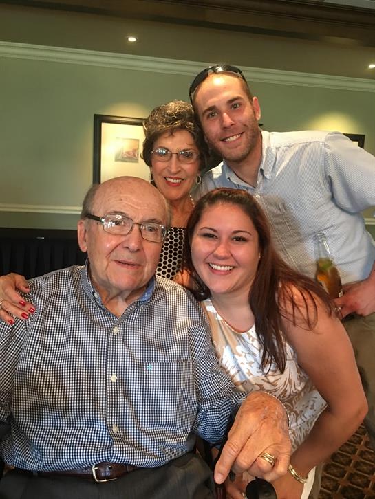 Four family members share smiles and laughter during a joyful restaurant celebration.