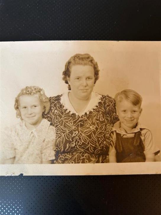 A woman poses with a girl and a boy, showcasing a nostalgic vibe and familial bonds.