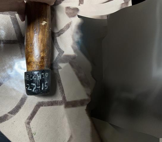 A hand holding a wooden hammer