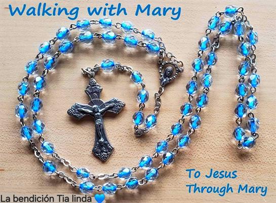 A blue beaded rosary with a silver cross reflects deep devotion and spiritual connection.