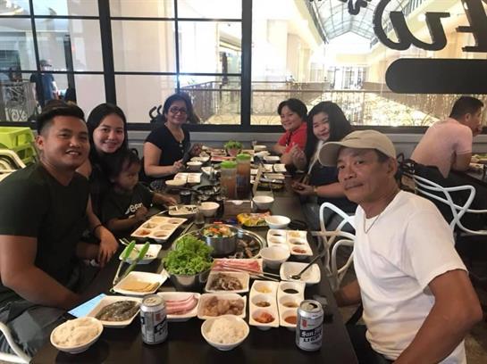 Friends and family share a hearty dinner at a bustling restaurant filled with tasty dishes.