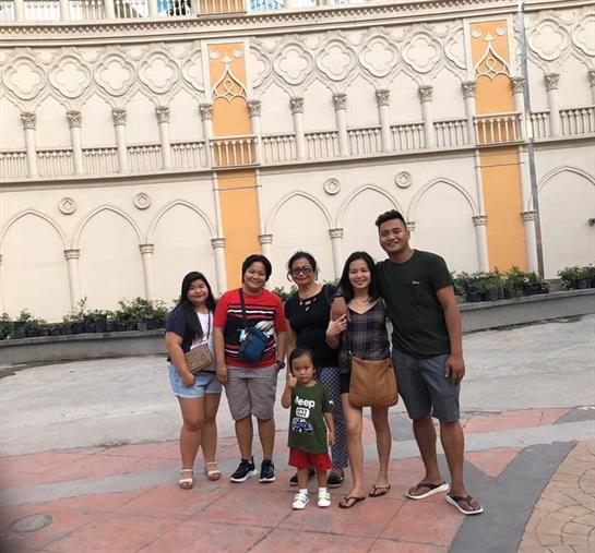 A family poses together at a colorful park with warm smiles, enjoying their time.
