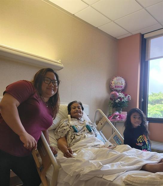 Family members share a heartfelt visit with a patient in a bright hospital room.