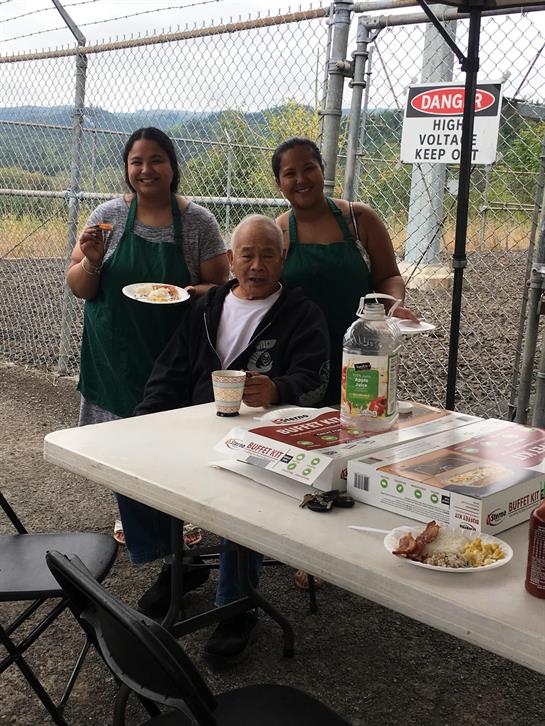 A group of people standing next to a table with food