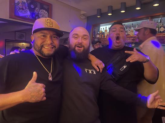 Three friends enjoy a fun night out in a lively bar filled with laughter and excitement.