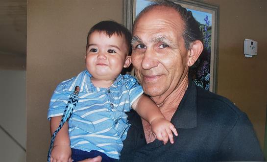 A cheerful grandfather embraces his young grandson in a cozy living room filled with warmth.