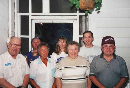 Friends gather inside a welcoming space, sharing smiles and camaraderie during summer.