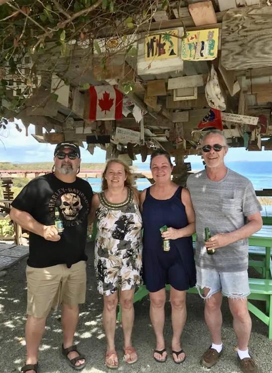A group of people standing under a wooden structure