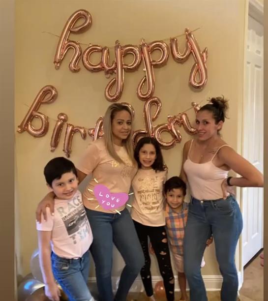 Families gather to celebrate a birthday with balloons and smiles, enjoying each other's company.