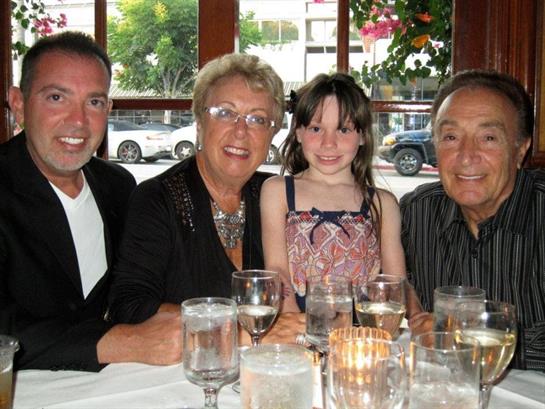 Four people enjoy a meal together at a restaurant, sharing laughter and smiles.