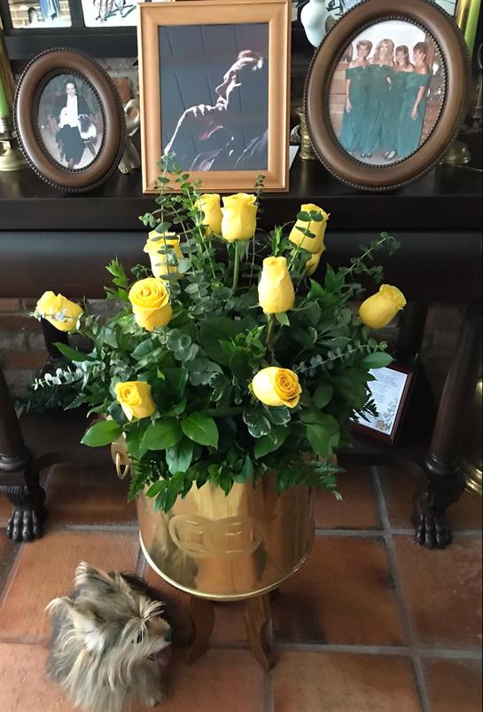 A bouquet of yellow roses in a bucket