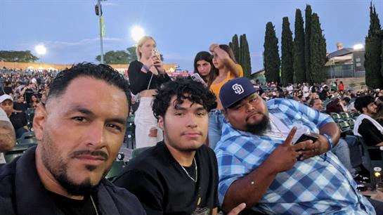 Friends gather at an outdoor concert, enjoying music and each other's company on a warm evening.