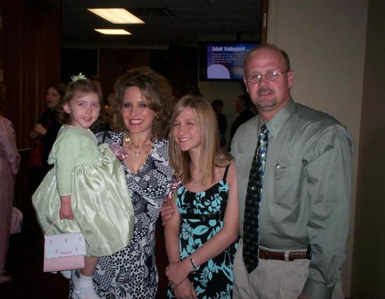 Family members enjoy a formal gathering, sharing smiles and dressed elegantly in a warm setting.