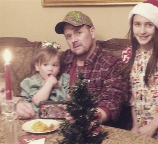 A family enjoys a holiday gathering with children, decorations, and festive food at home.