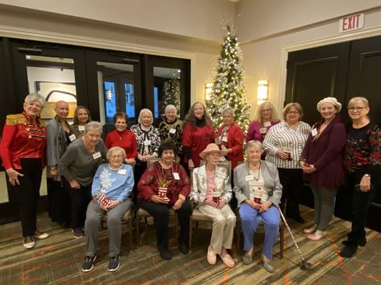 Seniors dressed in colorful outfits enjoy a festive gathering with holiday decorations.