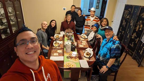 Friends and family share laughter and delicious food during a festive gathering at home.