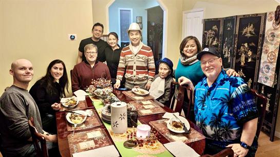 Group enjoys a hearty winter feast together, sharing laughter and stories at the dining table.