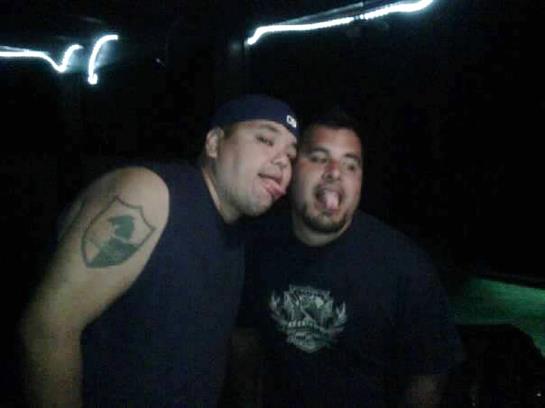 Two friends are making funny faces while standing close together in a lively atmosphere.