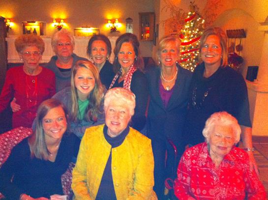 A gathering of women enjoying each other's company in a warm, decorated environment.