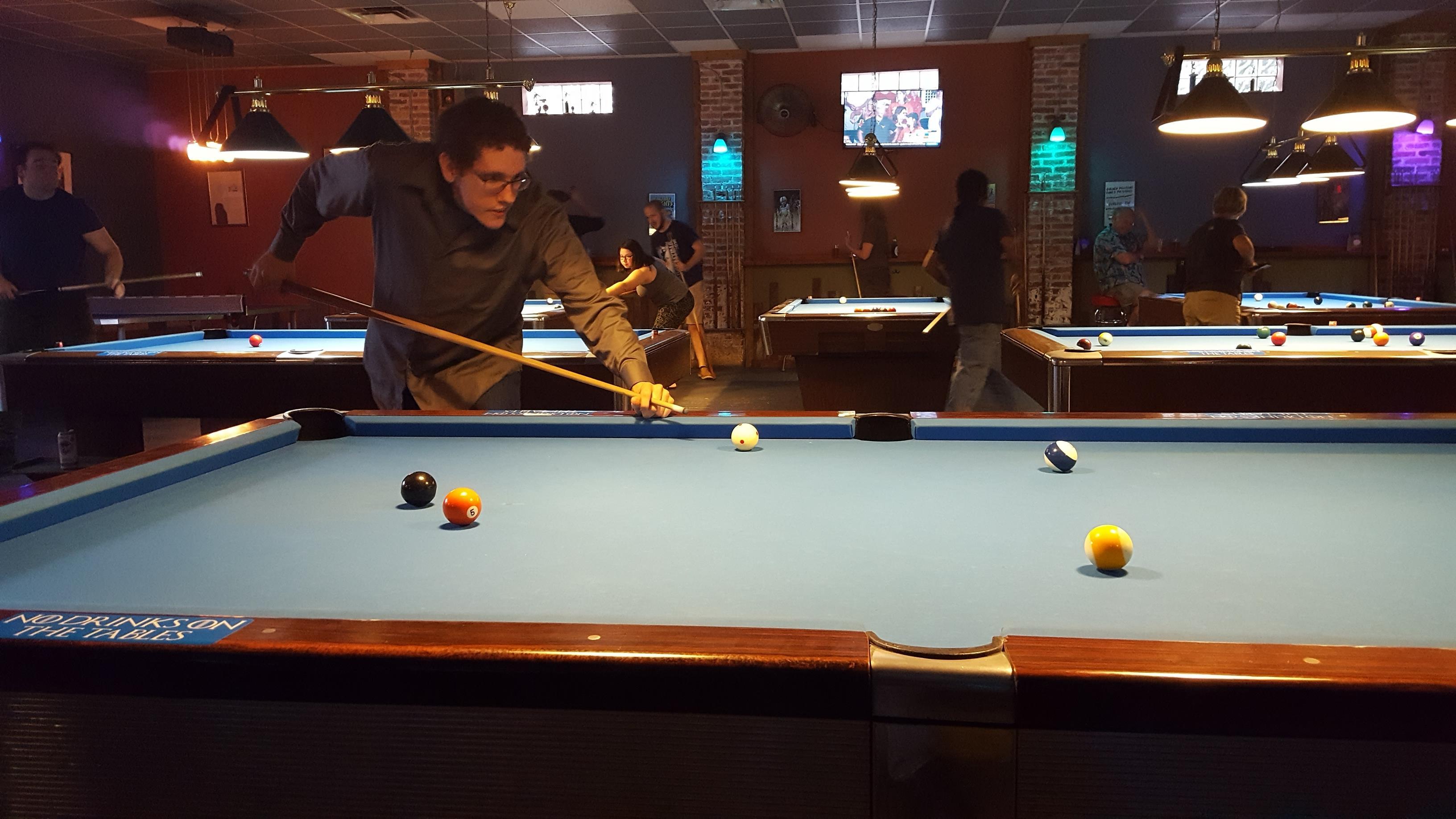 A man playing pool in a bar