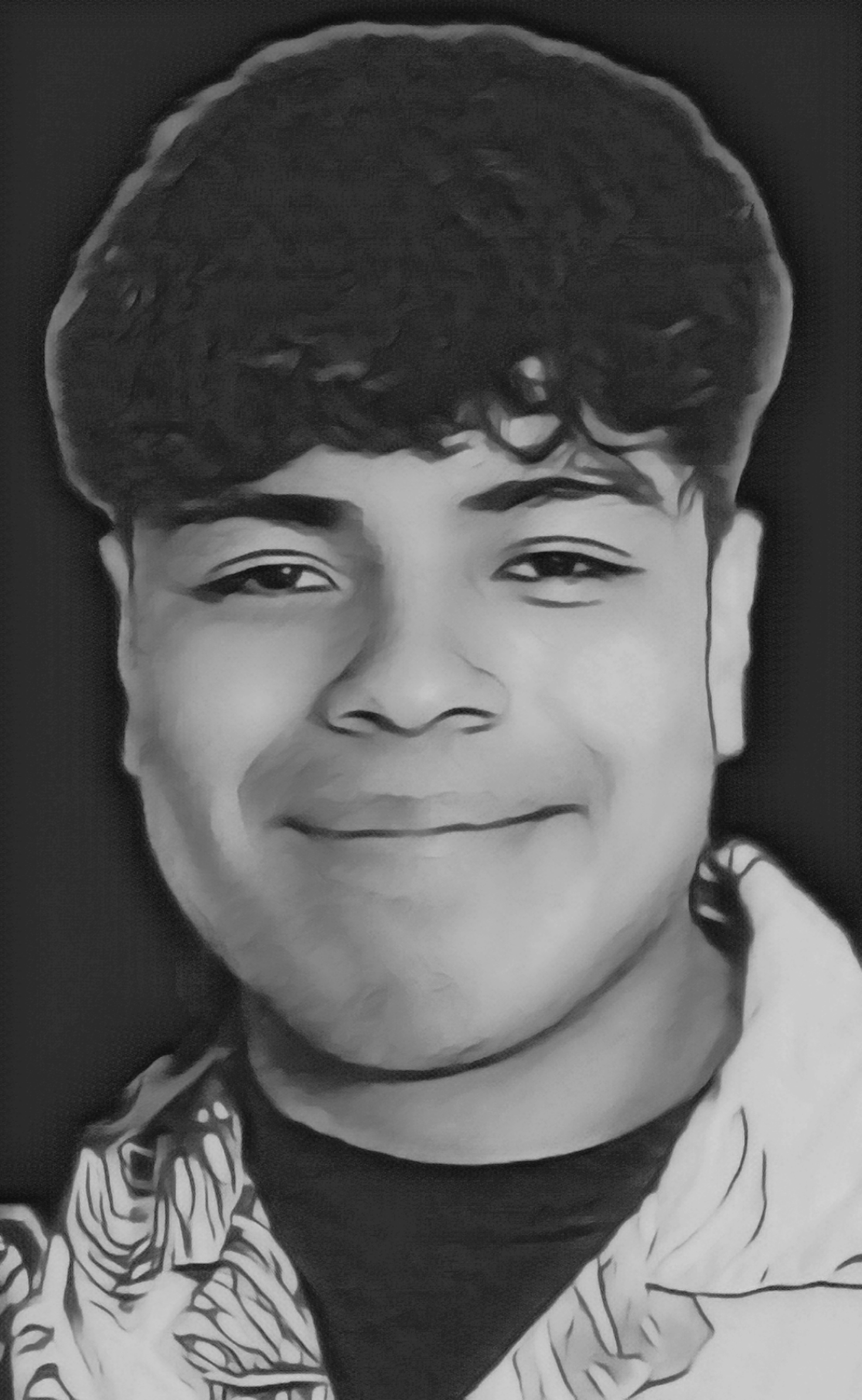 A young man with curly hair is smiling warmly while wearing a casual shirt. The background is dark.