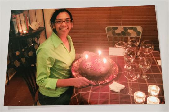 A woman holding a cake with candles