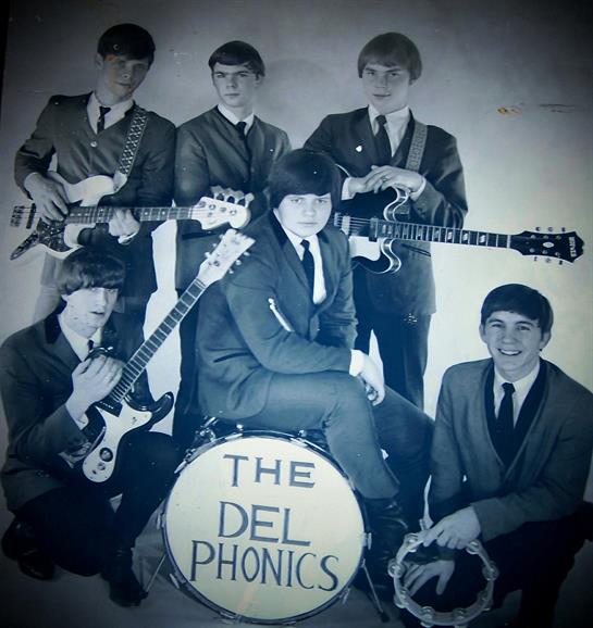 Six musicians pose with their instruments, showcasing vintage rock style and classic vibes.