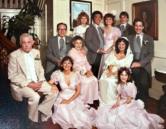 A joyful gathering of family members in formal attire captured in a vintage setting.