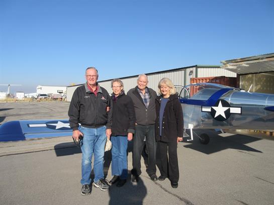 A group of people standing in front of a plane
