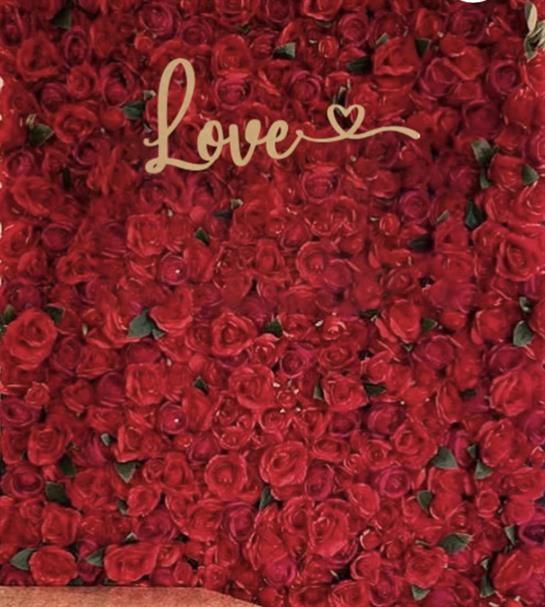 A vibrant arrangement of red roses with a decorative love sign captures romantic elegance.