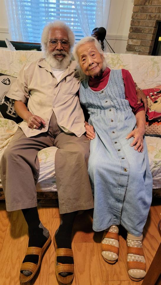 A happy elderly couple enjoys each other's company in their comfortable living room.