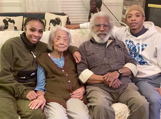Family members gather together, sharing warmth and joy in a living room filled with affection.