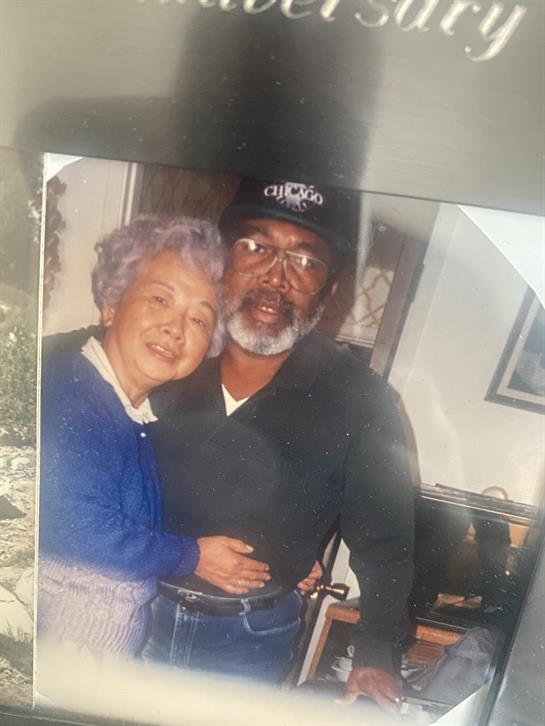 An elderly couple embraces warmly at home, celebrating their love and connection.