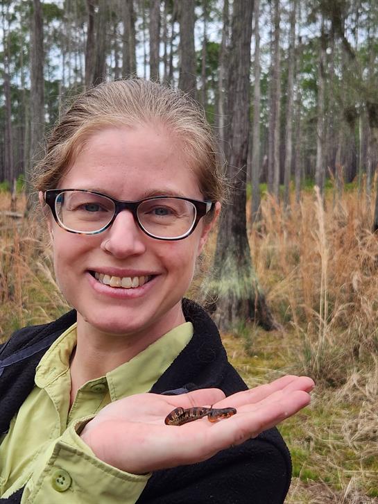 A woman holding a caterpillar on her hand