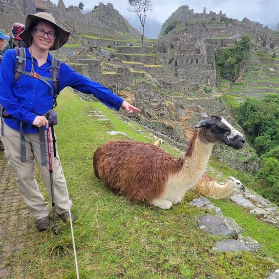 A woman pointing at a llama