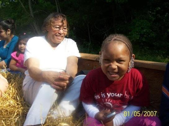 Joyful moments shared between a child and an elder in a rural setting filled with hay.