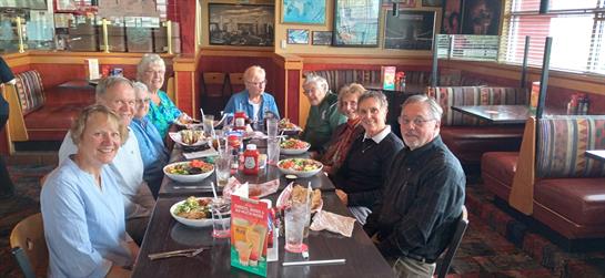 A group of friends enjoys lunch together at a restaurant, laughing and sharing meals.