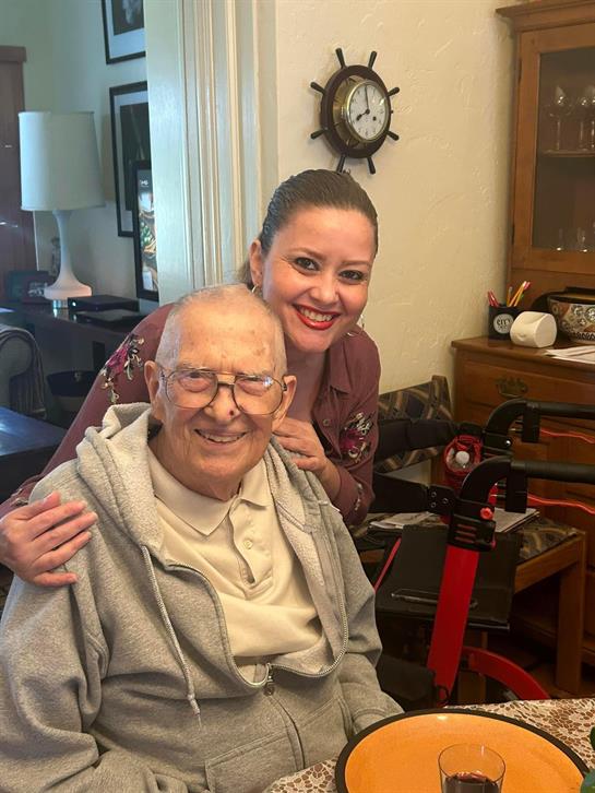Happy moments shared between an elderly man and his caregiver in a cozy living room.