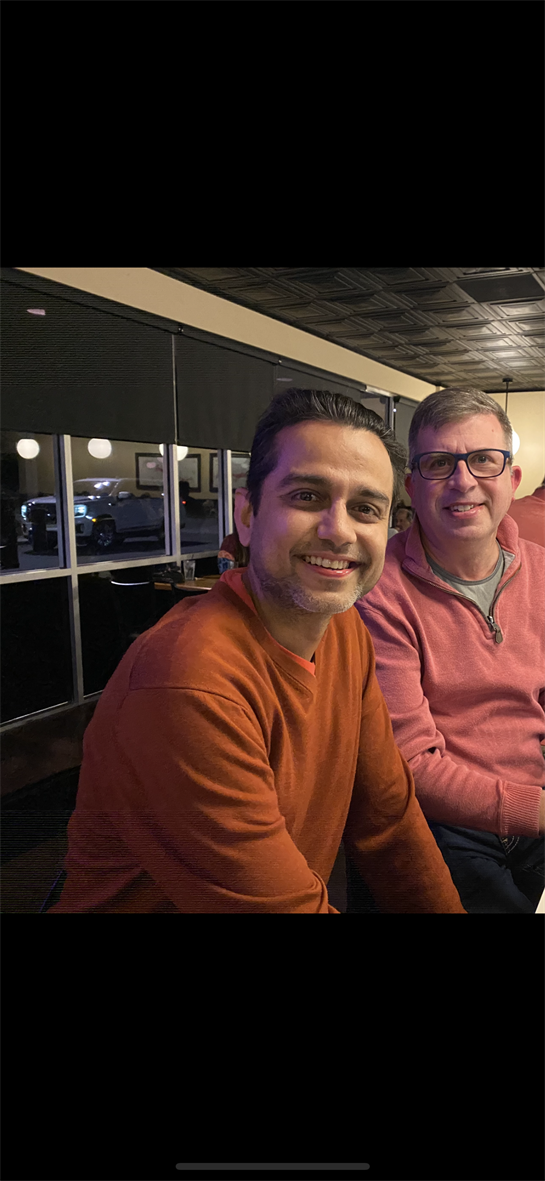 Two friends share a light-hearted moment at a cozy restaurant, enjoying their time together.