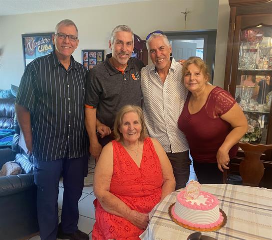 Family members gather to celebrate a birthday, smiles and warmth fill the cozy living space.