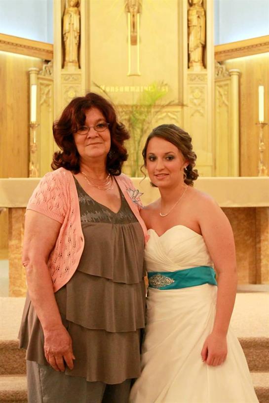 Two women standing together in front of a gold altar