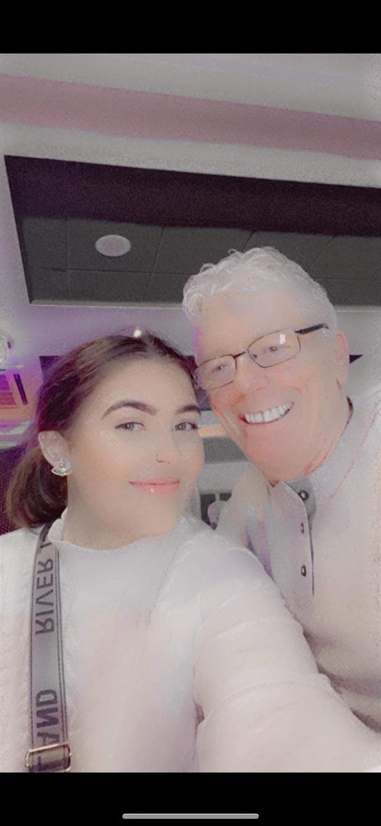 Friends pose happily for a selfie at a vibrant indoor event, smiling and enjoying their time.