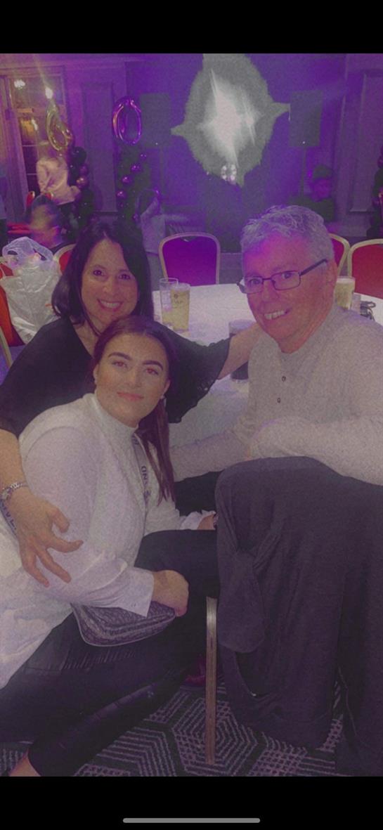 Family members enjoying time together during a celebratory event at a lively venue.