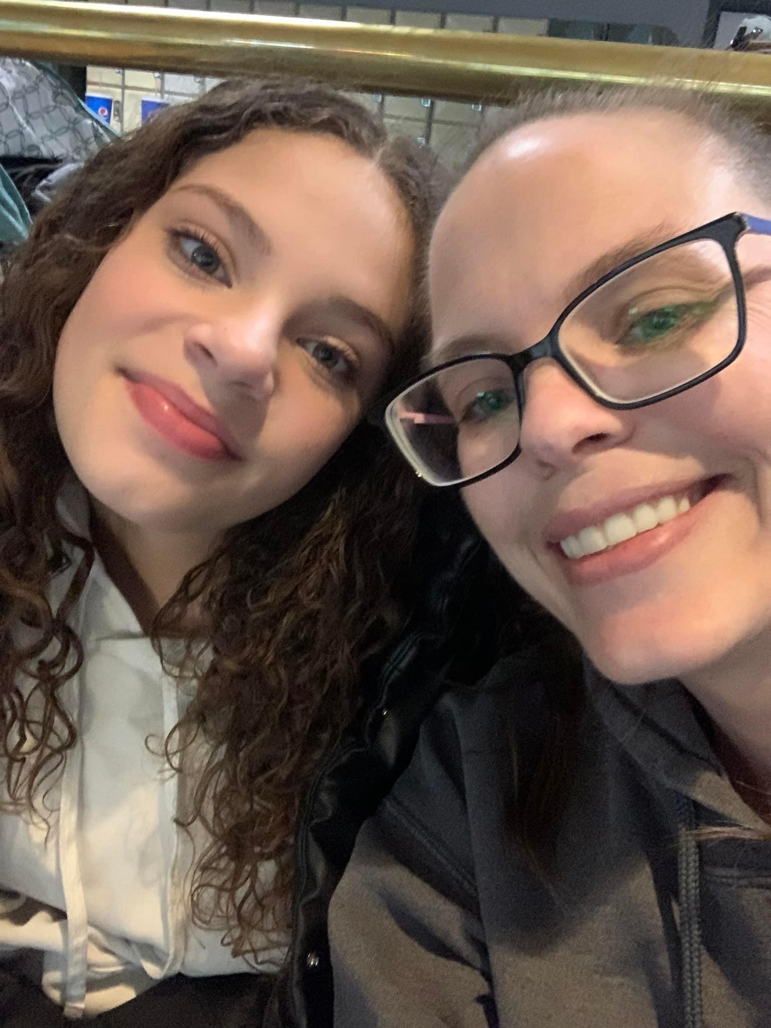 Two smiling individuals pose closely for a selfie at the airport, capturing a happy moment together.