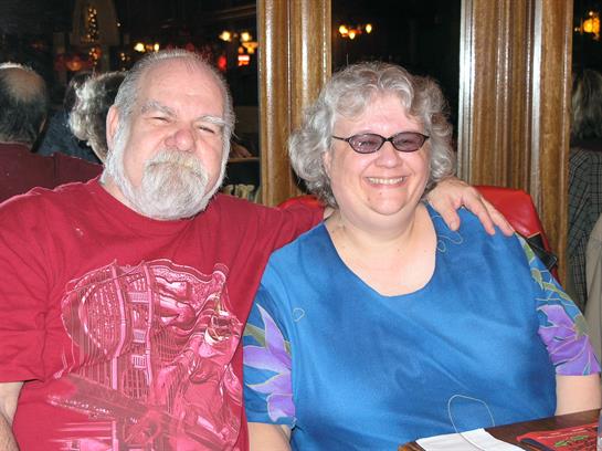 Two people sit together at a restaurant table, smiling and enjoying a pleasant moment.