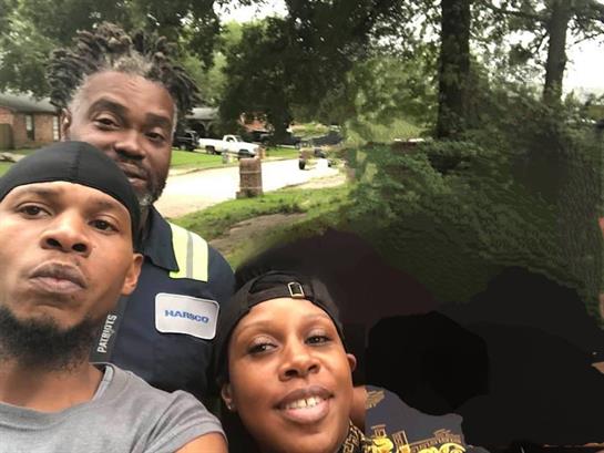 Friends pose for a selfie outside on an overcast day in a residential neighborhood.